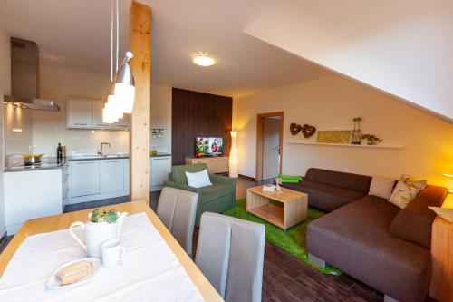 a living room and kitchen with a couch and a table at Seehaus Winkler in Weissensee