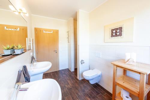 a white bathroom with a sink and a toilet at Seehaus Winkler in Weissensee