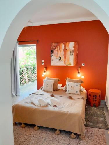 a bedroom with two beds and an orange wall at Vent Des Dunes in Essaouira