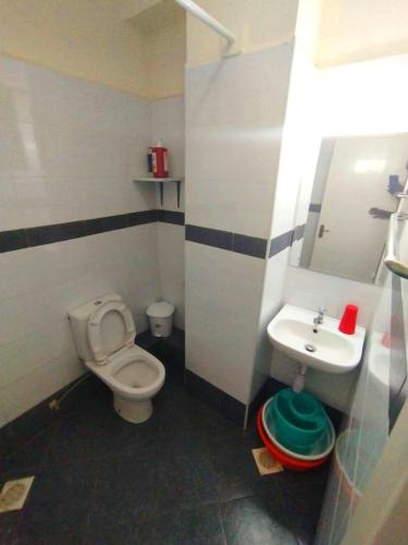 a small bathroom with a toilet and a sink at pgs plaz in Nakuru