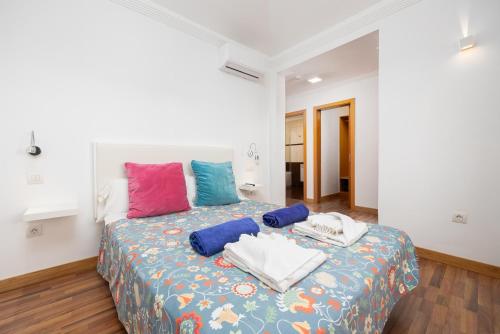 ein Schlafzimmer mit einem Bett mit bunten Kissen darauf in der Unterkunft Villa Ariel in Playa Blanca