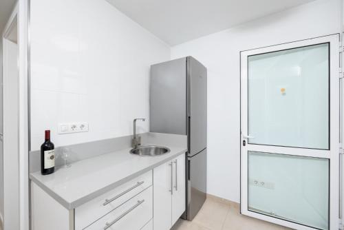 uma cozinha branca com um lavatório e um frigorífico em Villa Beyond em Playa Blanca
