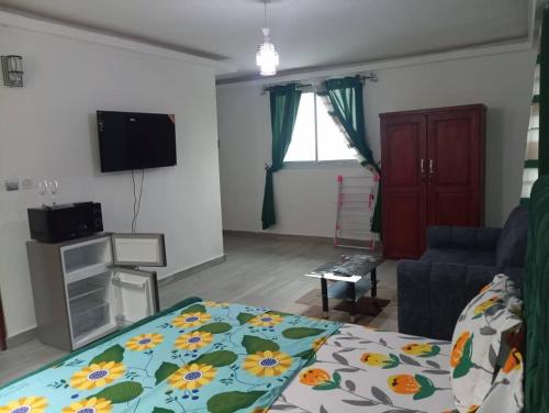 a living room with a bed and a couch at Makeena Berry Cosy Mboa - OLYMPE in Douala