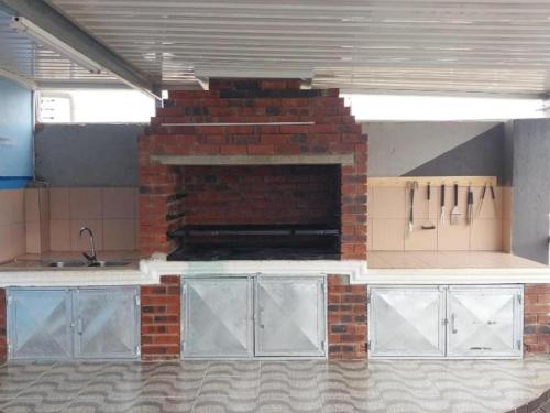 a kitchen with a brick fireplace in a room at MKHUZE INN in Mkuze