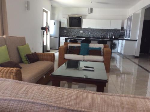 a living room with a couch and chairs and a table at Fortuna Beach in Flic-en-Flac