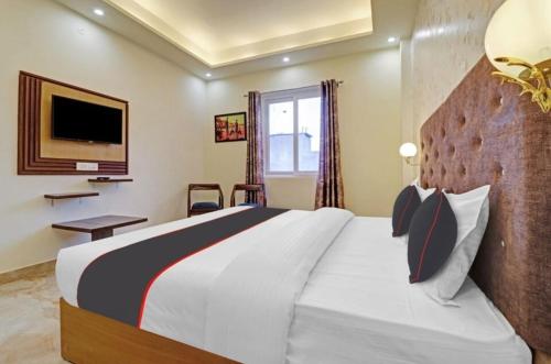 a bedroom with a large bed and a television at Willow Wood in Dehradun