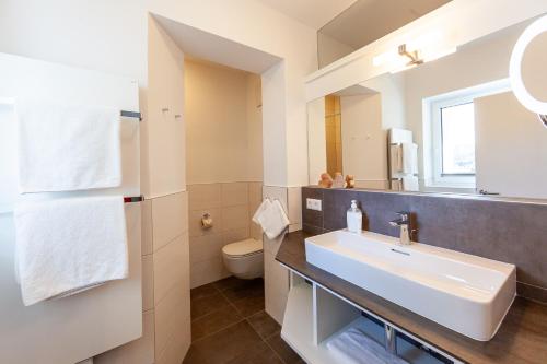 a bathroom with a sink and a toilet at Seehaus Winkler in Weissensee