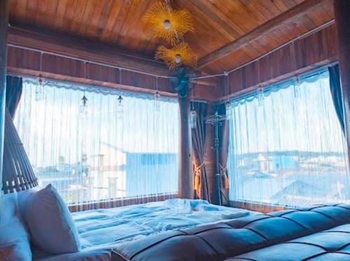 ein Schlafzimmer mit einem Bett und einem großen Fenster in der Unterkunft Oceanside Villa Phuquy Island in Cu Lao Thu
