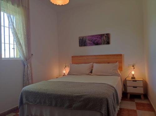 a bedroom with a bed and a window and two lights at Chalet Isla Sicilia in Novo Sancti Petri