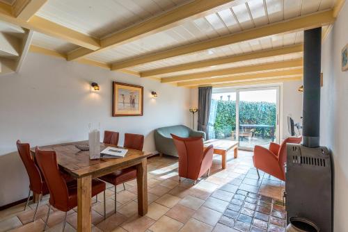a living room with a wooden table and chairs at Boerderijwoning De Florijn in Oosterend