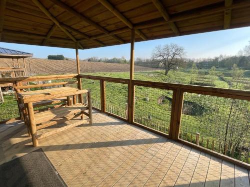 a porch with a wooden bench and a view of a field at Ecau Lodge - Logement insolite à 30km de Pairi Daiza in Écaussinnes-dʼEnghien
