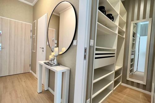 a bathroom with a mirror and a sink and shelves at Luxusný apartmán s parkovaním in Miloslavov