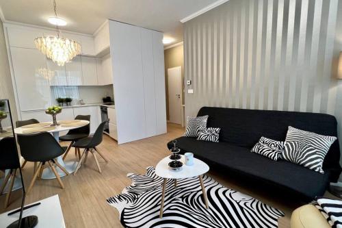 a living room with a black couch and a table at Luxusný apartmán s parkovaním in Miloslavov