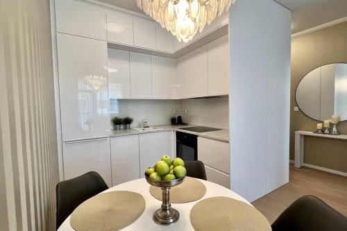 a kitchen with a table with a bowl of fruit on it at Luxusný apartmán s parkovaním in Miloslavov