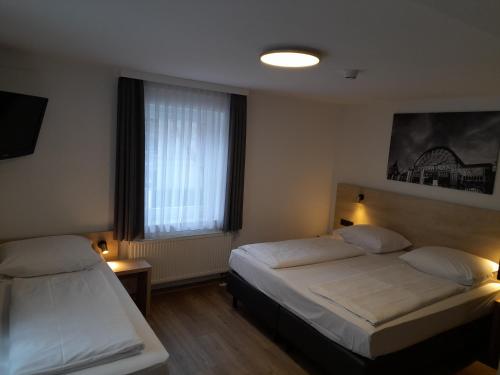 a bedroom with two beds and a window at Hotel am Park in Rust