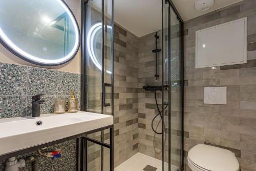 une salle de bain avec un lavabo et une douche en verre dans l'établissement L'élégance du Capitole, à Toulouse