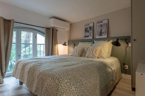 une chambre avec un lit et une grande fenêtre dans l'établissement L'élégance du Capitole, à Toulouse