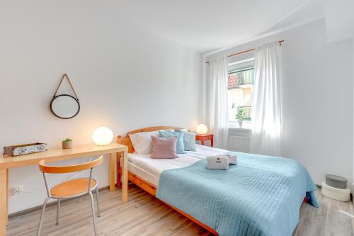 a small bedroom with a bed and a desk at TOTU HOME Molo Apartments Sopot Centrum in Sopot