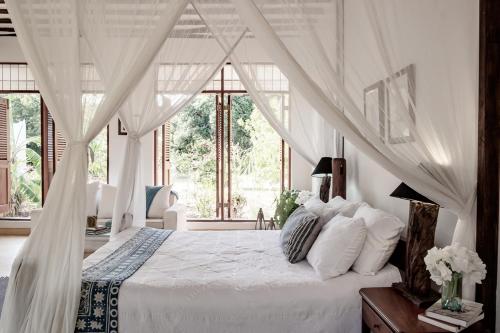a bedroom with a white bed with a canopy at Tarangau Retreat in Kilifi