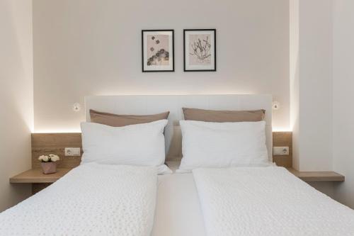 two beds with white pillows in a bedroom at Haus Wiesenstein in Lana