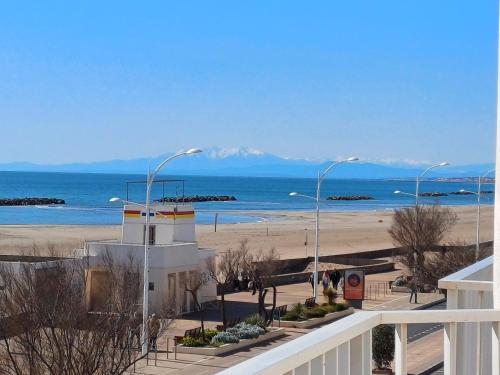 a view of a beach with street lights and the ocean at Hôtel de la Mer in Valras-Plage