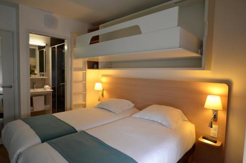 サン・ジル・クロワ・ド・ヴィにあるTERNELIA Le Vent Du Largeのベッドルーム(白いベッド2台、ランプ2つ付)