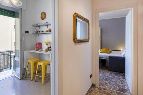 Zimmer mit einer Küche mit gelben Stühlen und einem Schlafzimmer in der Unterkunft Alla Goccia by Wonderful Italy in Genua