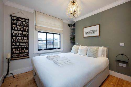 a bedroom with a large white bed with a window at Veeve - Bloomsbury Culture in London