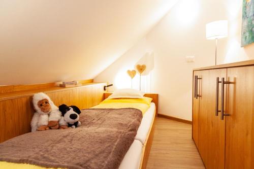 a bedroom with two stuffed animals sitting on a bed at Seehaus Winkler in Weissensee