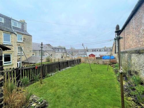 un patio con una valla y algunas casas en East side en Hawick