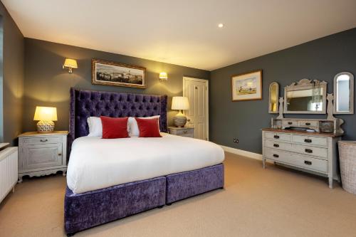 een slaapkamer met een groot bed met rode kussens bij Veeve - Parkside Purity in Londen