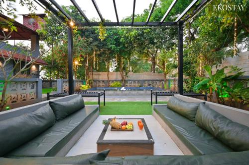 a patio with a couch and a table with fruit on it at EKO STAY- Brickstone Villa in Igatpuri