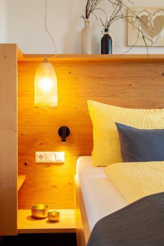 a bedroom with a bed with a wooden head board at Seehaus Winkler in Weissensee