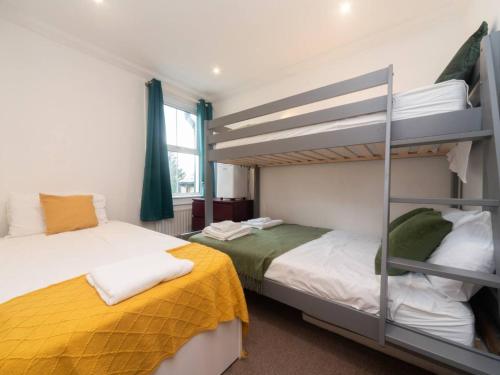 a bedroom with two bunk beds and a window at Pass the Keys Modernised family-friendly cottage in Surbiton