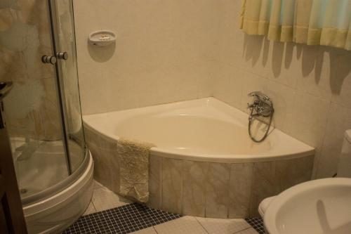 a bathroom with a bath tub next to a toilet at Waterfalls hotel (Lusaka) in Lusaka