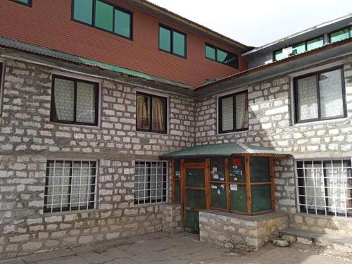 un edificio de ladrillo con puertas y ventanas de madera en Hotel Summit en Dingboche