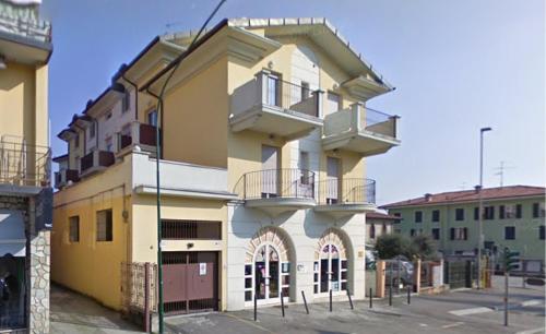 Gussago的住宿－La mansarda，黄色和白色的建筑,设有阳台
