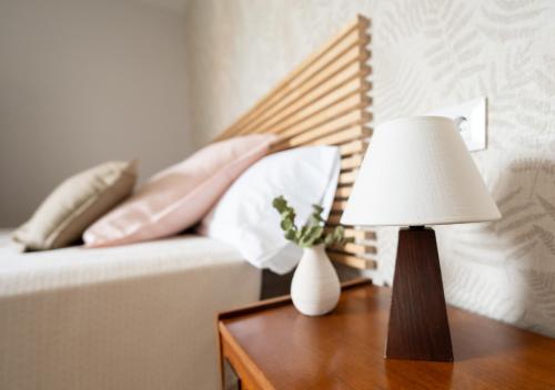 a lamp on a table next to a couch with pillows at Casa Manolo in Luanco
