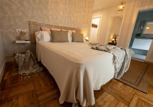 a bedroom with a large bed with a white blanket at Casa Manolo in Luanco