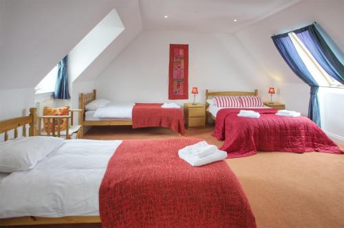 a bedroom with two beds with red and white sheets at Ettrick View in Selkirk