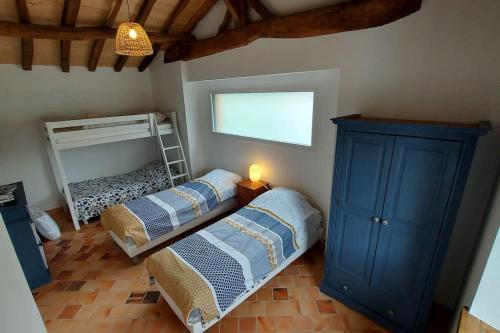 1 dormitorio con 2 camas y armario azul en Gite 6 personnes entre mer et ville au calme de la campagne, 2 chambres, en Saint-Même-le-Tenu