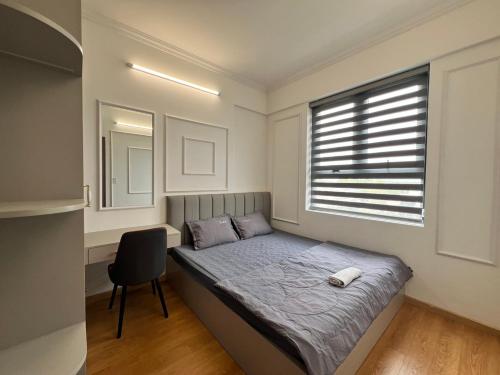 a bedroom with a bed with a chair and a window at OSIMI Apartment - 2 Bedrooms - A0503 in Phú Mỹ