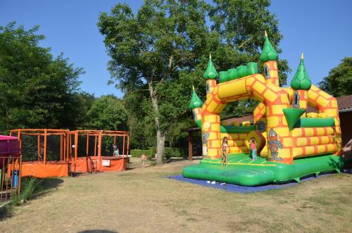 a playground with a inflatable play structure in a park at Flower Camping Les Mijeannes in Rieux-de-Pelleport