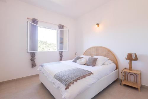 une chambre avec un lit blanc avec une fenêtre dans l'établissement Le Trois MC - Appt climatisé proche de la mer, à LʼÎle-Rousse