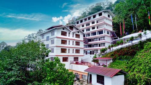 a white building on the side of a hill at Voyage Dreamvilla Retreat in Pelling