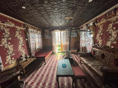 斯利那加的住宿－Srinagar hotels and houseboats，带沙发、桌子和窗帘的客房