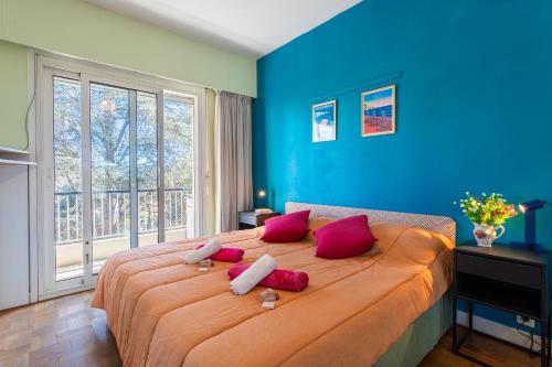 - une chambre bleue avec un grand lit et des oreillers rouges dans l'établissement LE MILLEANT AP4393 By Riviera Holiday Homes, à Nice