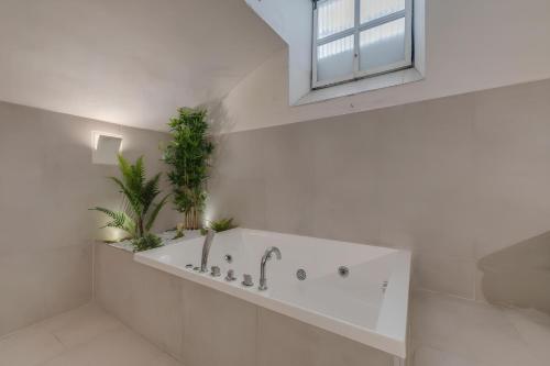 un bagno bianco con vasca e piante di Residenza d'Epoca Galleria dell'Accademia a Firenze