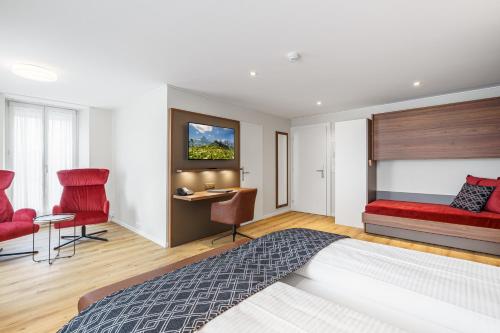 a bedroom with a bed and a desk and chairs at Hotel Du Nord in Interlaken