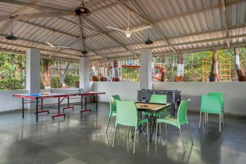 a dining room with tables and green chairs at Nature Trails Durshet, Khopoli in Khopoli